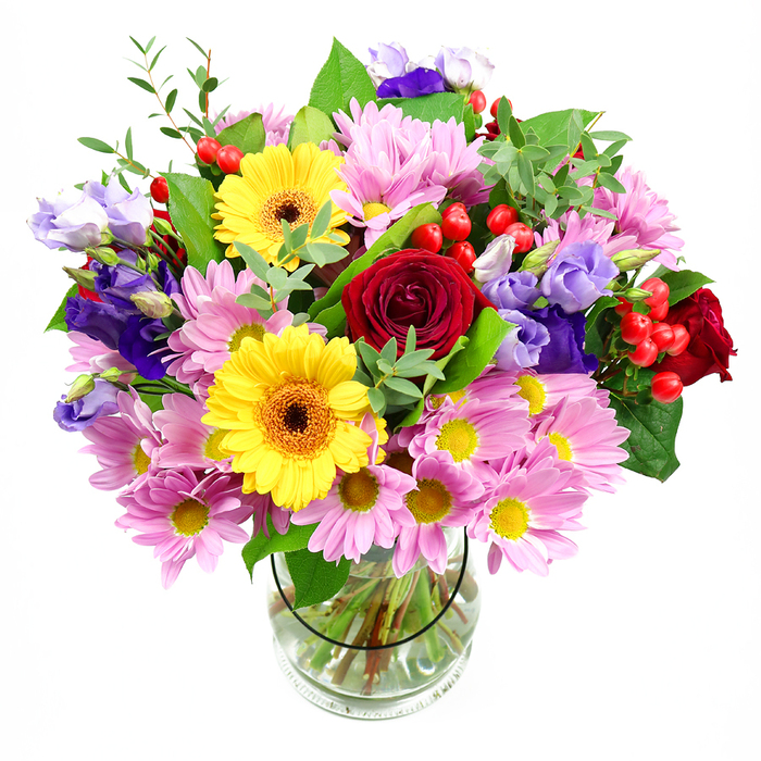 In this photograph, a lush mixed bouquet is presented in a transparent glass vase, set against a pure white background that makes the colours appear particularly vivid. Dominating the heart of the arrangement are several deep red roses, their petals opening in soft spirals that exude richness and emotional depth. Near them, two bold yellow gerbera daisies with dark brown-orange centres stand like cheerful focal points, adding a sunny, uplifting note that would feel right at home in a Gospel Oak kitchen or living room. Encircling these central flowers is a profusion of pink daisies or chrysanthemums, each bloom made up of slender, overlapping petals arranged around a tiny yellow eye, building a sense of rounded fullness and gentle softness. Scattered throughout are stems of lisianthus in purple and lavender tones, their delicate bell-shaped blossoms and ruffled edges bringing cooler hues and a touch of quiet refinement, like the calming atmosphere of nearby Hampstead Heath in the evening. Interspersed among the blooms, clusters of bright red hypericum berries provide rounded, glossy accents, adding an extra layer of texture that invites the eye to move around the arrangement. The bouquet is completed with layers of greenery in varying shapes and shades of green-from broad, deep-toned leaves to finer, more feathery foliage-giving the design a natural, garden-inspired feel. Through the clear sides of the vase, you can see the neatly trimmed stems crossing in clear water, arranged with the tidy precision characteristic of Gospel Oak Flowers. The overall impression is one of generous joy and thoughtful craftsmanship, ideal for birthdays, thank-you gestures, or simply bringing a sense of celebration into a Gospel Oak home.