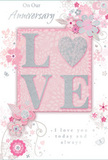 The anniversary card in this image feels like a tender nod to long-lasting love, composed with the finesse of a bespoke arrangement from a Gospel Oak florist. Its colour scheme blends soft pastel pinks with silvery greys, creating an atmosphere of cherished intimacy, like the quiet hush of an evening walk past the trees that lead up toward Parliament Hill. At the centre, the word LOVE stands out in raised, softly glittered letters, each stroke shimmering with fine sparkle. The letter O has been transformed into a silver, textured heart, slightly embossed and gleaming gently against the blush background, much like a single standout bloom at the heart of an anniversary bouquet. Around this focal point, delicate flowers in blush and mauve seem to unfurl across the card. Their edges are softly defined, giving them a watercolor feel, and the fine, flowing lines that trace their petals and stems suggest care, lightness, and movement. Tiny decorative touches-petals, elegant swirls, and subtle butterfly motifs-are scattered throughout, adding a sense of whimsy and motion, as though a light spring breeze had stirred an English garden near Gospel Oak station. These details remain refined and understated, keeping the design poised rather than busy. The phrases On Our Anniversary and I love you today and always appear in an elegant, flowing script that complements the more textured central word, delivering a message of enduring affection without overshadowing the artwork. Altogether, the card feels like a keepsake: soft-spoken yet deeply heartfelt, a perfect companion to fresh anniversary flowers delivered across Gospel Oak and the surrounding streets for couples celebrating their shared journey.